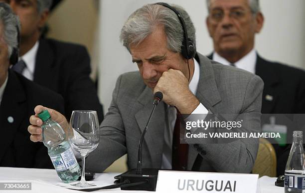 Rio de Janeiro, BRAZIL: El presidente de Uruguay, Tabare Vazquez, observa la etiqueta de una botella de agua mineral uruguaya, mientras escucha el...