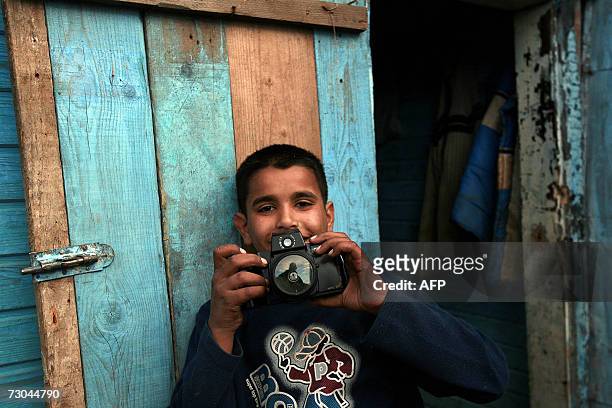 Roma boy plays with a camera in the Zitkovac refugee camp in North Mitrovica, 19 January 2007, where 40 families including 100 children live near...
