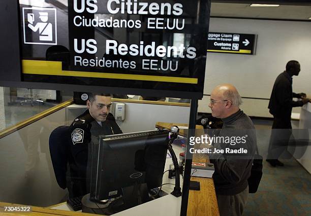Anthony Ramos, a Customs and Border Protection officer, checks Martin Keenan in at the passport control area January 19, 2007 at Miami International...