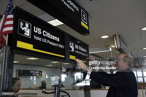 William Kuiken, from the Miami-Dade Aviation department, changes a sign at the U.S. Customs and Border Protection Passport control area January 19,...