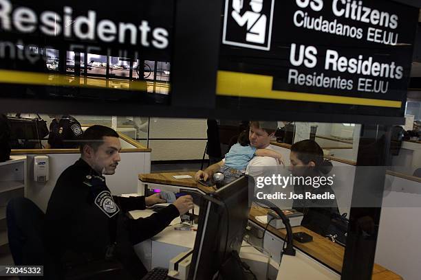 Anthony Ramos, a Customs and Border Protection officer, checks Chris Layman, Katy Layman, 21 mths old, and Natalie Layman in at the passport control...