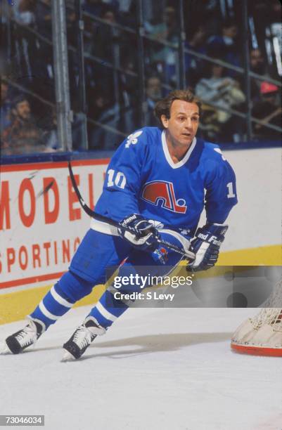 Canadian professional ice hockey player Guy Lafleur of the Quebec Nordiques on the ice behind a goal during a road game, late 1980s or early 1990s....