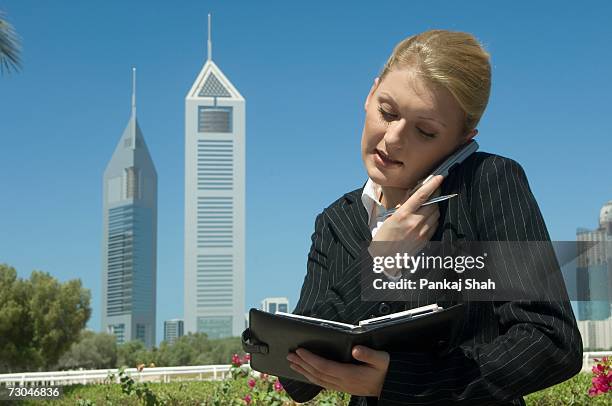 young businesswoman outdoors with modern office towers seen in the background - arab businesswoman with books stock-fotos und bilder