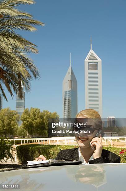 young businesswoman outdoors with modern office towers seen in the background - arab businesswoman with books stock-fotos und bilder