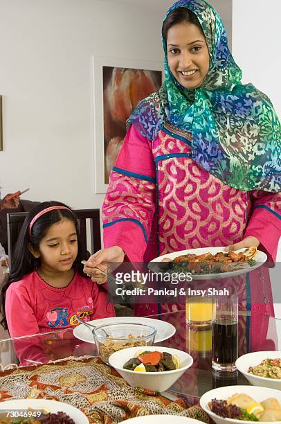 mother serving food to daughter - hot middle eastern girls stock pictures, royalty-free photos & images