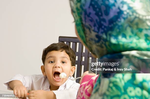 mother feeding son - wellness kindness love stock pictures, royalty-free photos & images