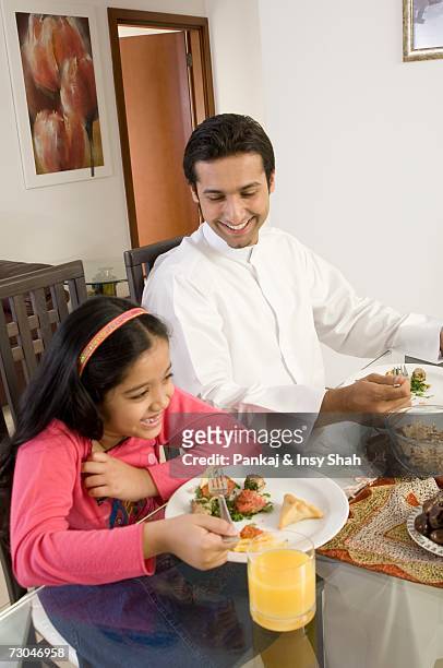 father and daughter eating at the dining table - hot middle eastern girls stock pictures, royalty-free photos & images