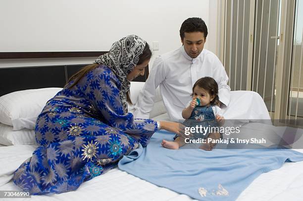 parents sitting on the bed in the bedroom playing with baby - hot babe - fotografias e filmes do acervo