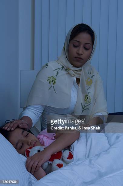 mother puts daughter to bed - hot middle eastern girls stock pictures, royalty-free photos & images