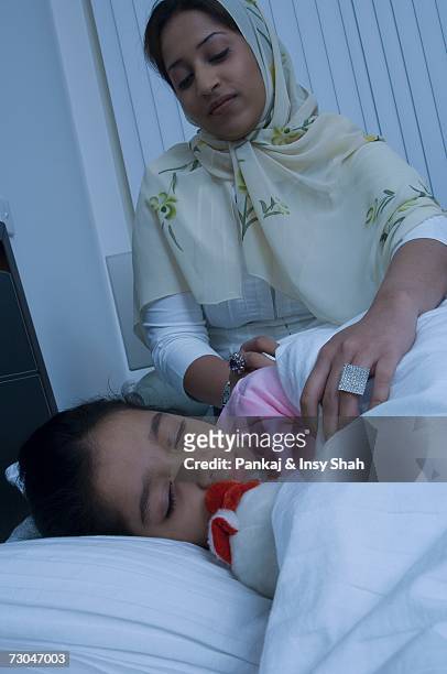 mother puts daughter to bed - hot middle eastern girls stock pictures, royalty-free photos & images