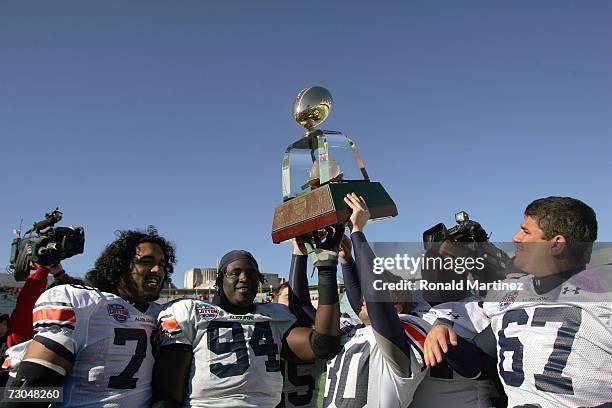 Oscar Gonzalez ,Sen'Derrick Marks and Kody Bliss of the Auburn Tigers celebrates with the trophy after winning the AT&T Cotton Bowl Classic against...