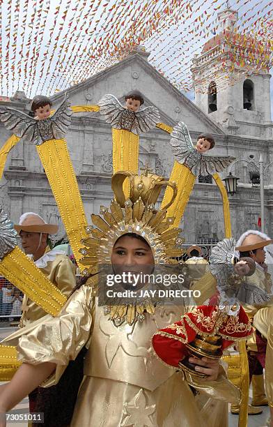 Performer symbolizing the Virgin Mary carrying Jesus as an infant parades after a mass at the Basilica Del Santo Nino in Cebu city, 20 January 2007....