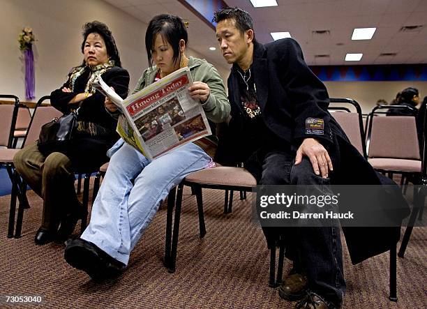 Michael Thao and wife Mai Her Vang , sister of Pang Vue the wife of slain Hmong hunter, Cha Vang, read a Hmong newspaper about the death of Cha Vang...