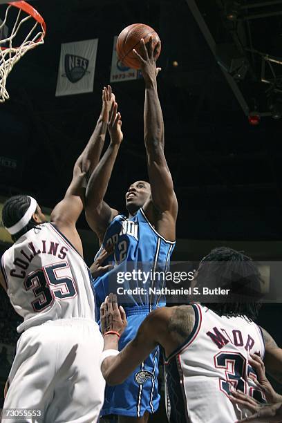 Dwight Howard of the Orlando Magic shoots against Jason Collins of the New Jersey Nets on January 20, 2007 at the Continental Airlines Arena in East...