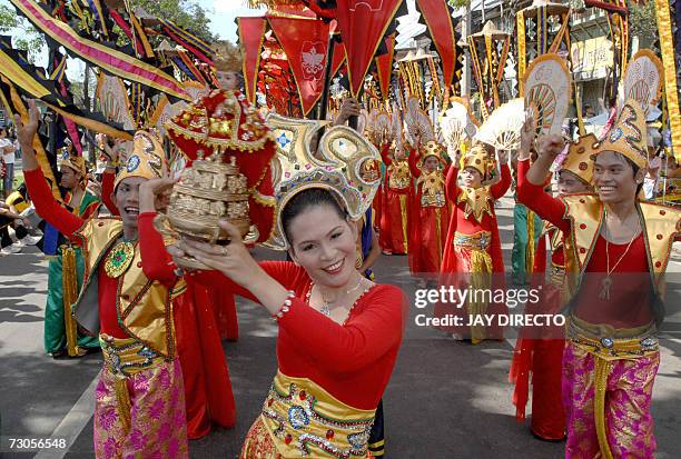 Performers dancing in the street holding a religious icon of the Santo Nino, during the culmination of the nine-day religious festival called...