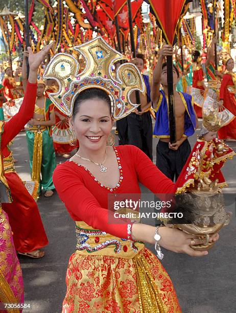 Performers dancing in the street holding a religious icon of the Santo Nino, during the culmination of the nine-day religious festival called...