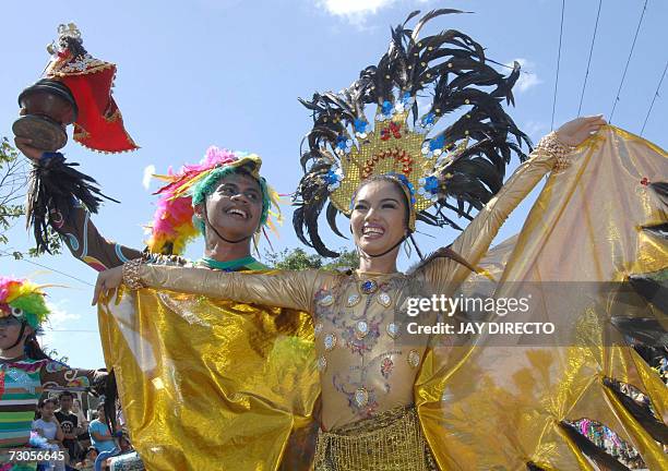 Performers dancing in the street holding a religious icon of the Santo Nino, during the culmination of the nine-day religious festival called...