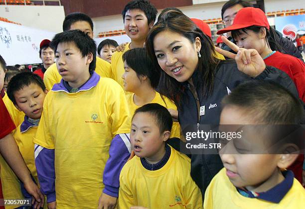 Figure-skating superstar Michelle Kwan poses with the handicapped Chinese athletics in Beijing 21 January 2007. The Hong-Kong born Kwan, a two-time...