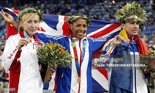 File photo taken 28 August 2004 shows women's 1500m gold winner Kelly Holmes of Britain celebrating on the podium with silver medalist Tatyana...