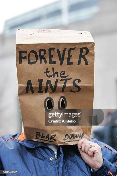 Fan with a paper bag on his head with the words "Forever the Aints Bear Down" on it stands outside before the NFC Championship Game between the New...