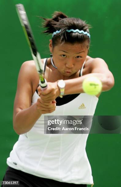 Yi-Miao Zhou of China plays a backhand during her first round juniors match against Ellen Barry of New Zealand on day eight of the Australian Open...