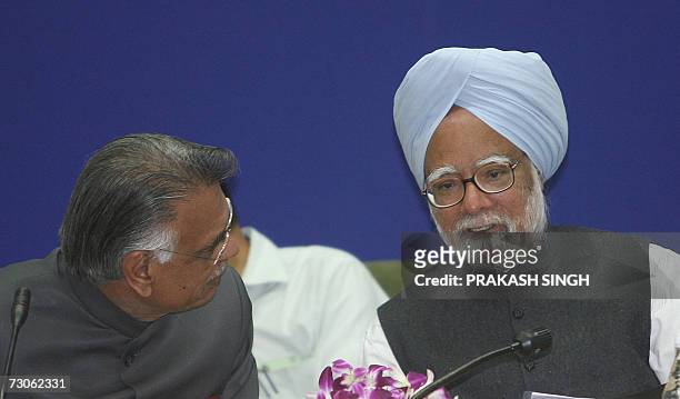 Indian Home Minister Shivraj Patil listens to Indian Prime Minister Manmohan Singh during a conference of Chief Ministers on pension reforms in New...