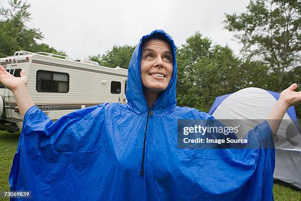 woman wearing a blue plastic raincoat - raincoat ストックフォトと画像
