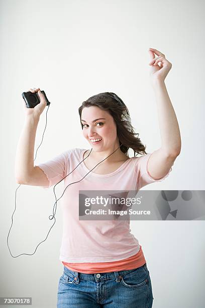 young woman listening to music - met de vingers knippen stockfoto's en -beelden