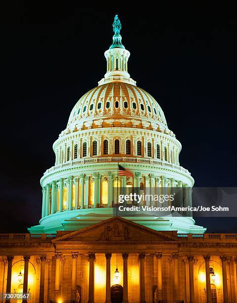 this is the u.s. capitol at dusk. the lights are on in the rotunda. we see it against a clear night sky. - capitol rotunda stockfoto's en -beelden