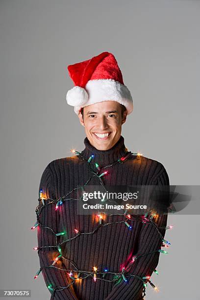 man tied up in christmas lights - santa hat stock pictures, royalty-free photos & images