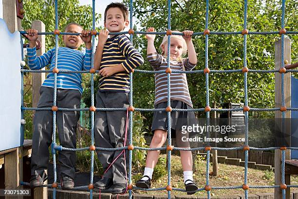 children on a rope climbing net - child climbing stock pictures, royalty-free photos & images