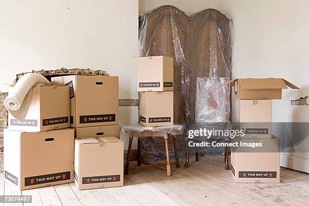 cardboard boxes and furniture in room - bubble wrap box stock pictures, royalty-free photos & images