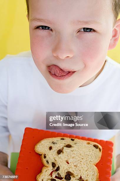 boy with slice of raisin bread - hungry child stock pictures, royalty-free photos & images