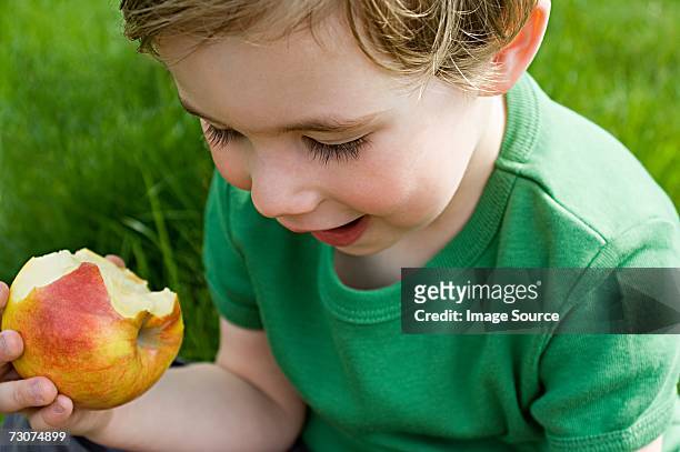 boy eating apple - croquer photos et images de collection