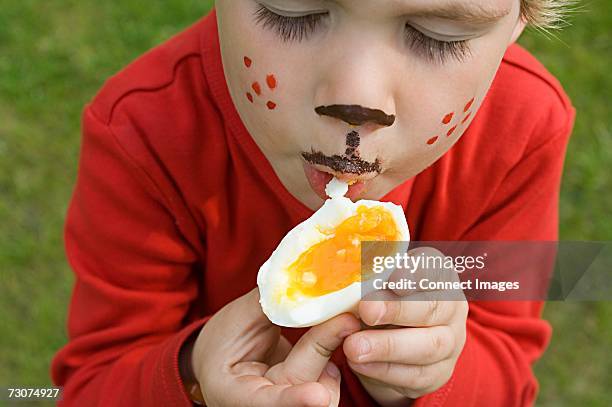 boy eating an egg - kid boiled egg stock pictures, royalty-free photos & images