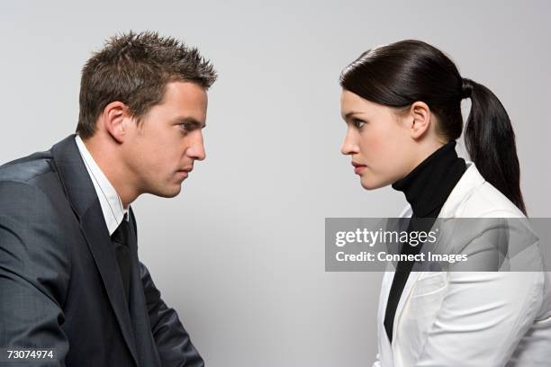 two rival colleagues - cara a cara fotografías e imágenes de stock