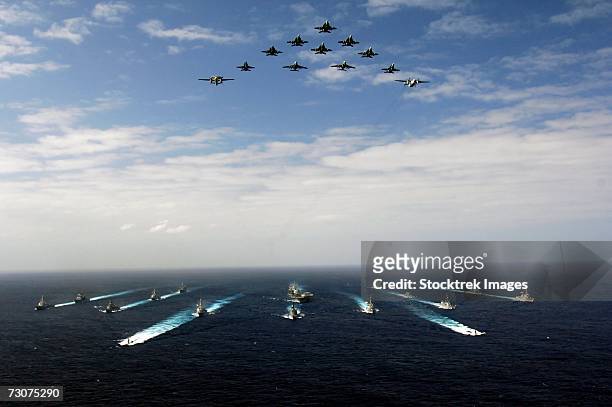 pacific ocean (november 14, 2006) - aircraft assigned to carrier air wing five (cvw-5) fly over a group of 18 u.s. and japanese maritime self-defense force ships, at the conclusion the two nations' exercise annualex. - us air force stock-fotos und bilder