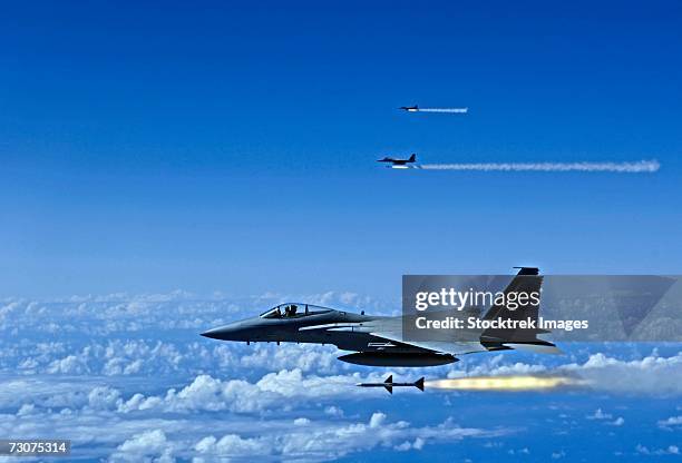 f-15 eagle aircrafts fire aim-7 sparrow missiles at a tactical air-launched decoy over hickam air force base, hawaii, july 16, 2006, during exercise rim of the pacific (rimpac) 2006. - rim fire foto e immagini stock