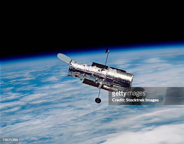 hubble space telescope in orbit around earth. - hubble space telescope stock pictures, royalty-free photos & images