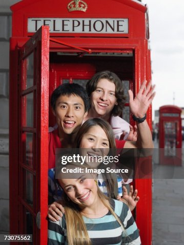 Tourists in a red telephone booth Tourists in a red telephone booth