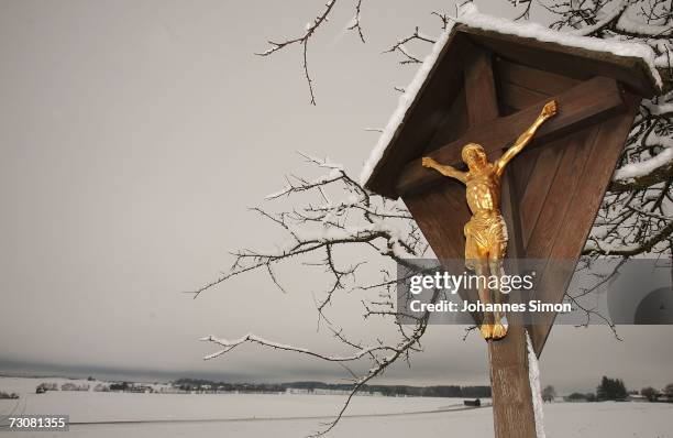 Field cross depicting the crucifixion of Christ stands in a snowy landscape of the Bavarian Prealps near the ham of Issing on January 23, 2007 in...