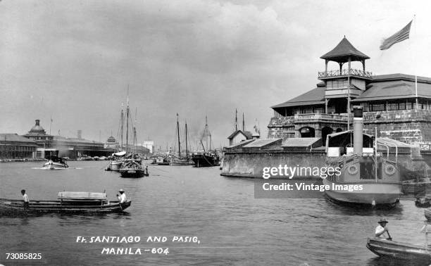 View of traffic on the Pasig River with Fort Santiago, citadel within the ancient walled city on the right, Manila, Philippines, early 20th Century....