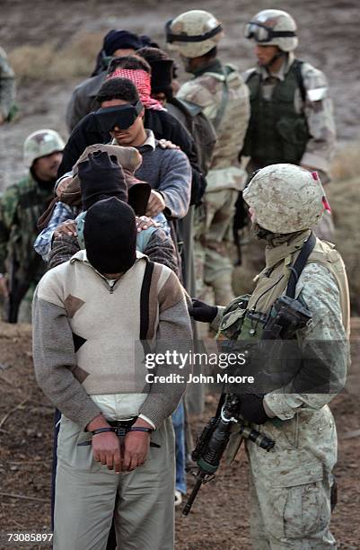 Marine , leads the way as Iraqi Army troops walk a group of detainees towards a combat outpost January 23, 2007 in Ramadi in Iraq's Anbar province....