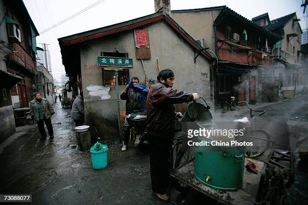 Vendor of a nearby store fetches hot water at a Laohuzao teahouse at an alleyway January 23, 2007 in Shanghai, China. Laohuzao is a traditional store...