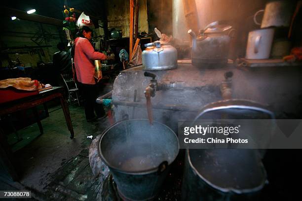 Worker boils water at a Laohuzao teahouse at an alleyway January 23, 2007 in Shanghai, China. Laohuzao is a traditional store which sells hot water...