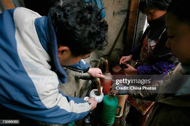 Residents buy hot water at a Laohuzao teahouse at an alleyway January 23, 2007 in Shanghai, China. Laohuzao is a traditional store which sells hot...