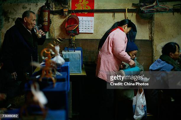 Worker adds boiled water for customers at a Laohuzao teahouse at an alleyway January 23, 2007 in Shanghai, China. Laohuzao is a traditional store...