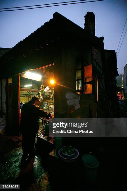 Resident fetches hot water at a Laohuzao teahouse at an alleyway January 23, 2007 in Shanghai, China. Laohuzao is a traditional store which sells hot...