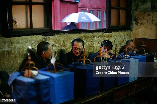 Senior citizens enjoy tea with their bird cages put aside at a Laohuzao teahouse at an alleyway January 23, 2007 in Shanghai, China. Laohuzao is a...