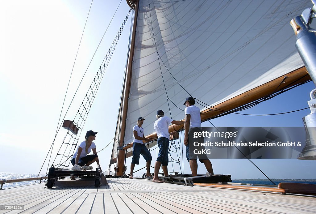 Sailboat captain and crew working on deck, ground view
